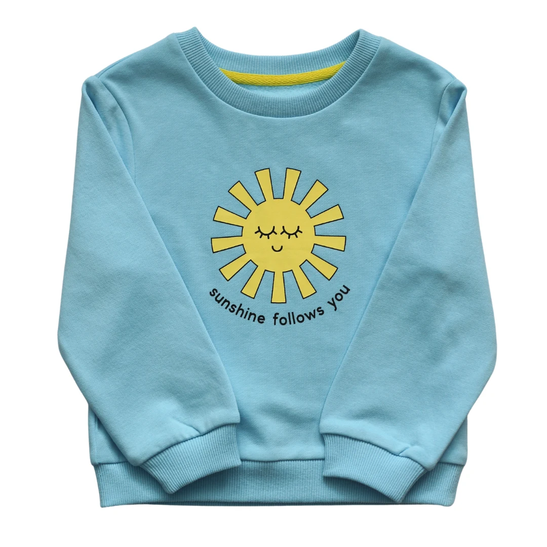 Sky-blue Sunshine Follows You sweatshirt with a yellow smiling sun graphic, laid flat on a white background